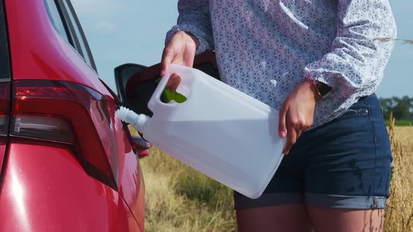 Close Up Woman Filling Up Diesel Exhaust Fluid DEF or Petrol From the Canister in the Field