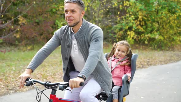 Happy Father and Daughter on Bike Ride in Park