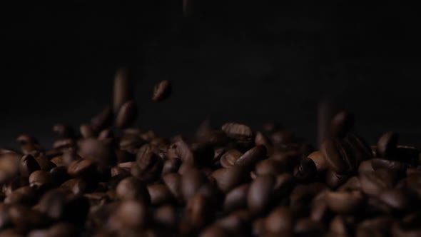 Slow motion of Raw coffee beans fall to the ground.