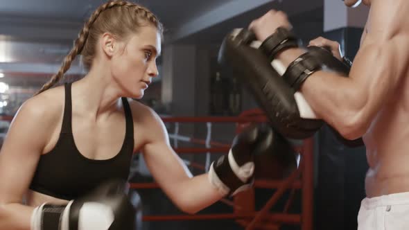 Female Fighter Trains Punches and Defence Punching Focus Mitts Training Day with Trainer in Boxing