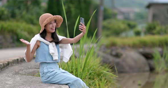 Woman taking selife on mobile phone at countryside