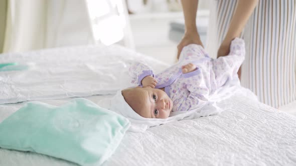 Mother in Striped Dress Takes Off White Bodysuit From Baby