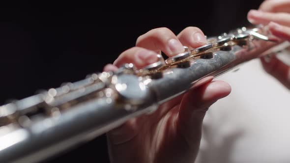 Female Musician Plays Music on Flute Doing Hobby Dark Background in Studio Closeup