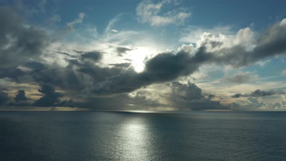 Stunning Scenery Of The Bright Sun Behind The Dramatic Clouds Above The Deep Blue Ocean In An Island