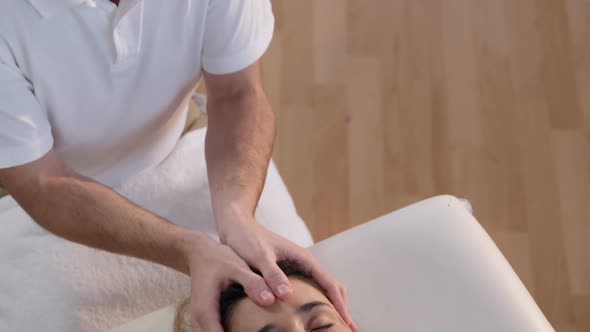 Female patient receiving head massage from physiotherapist