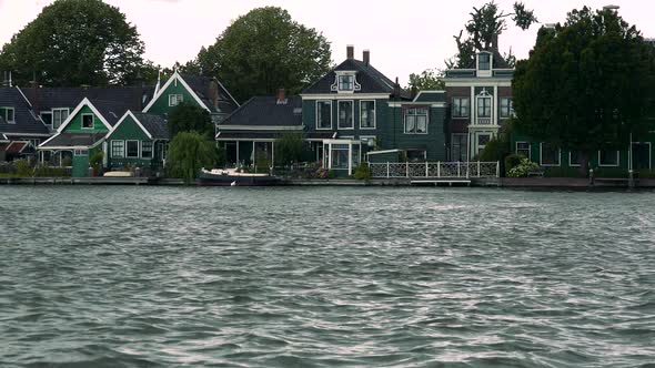 Houses By a River in a Rural Area, Tree Crowns and the Bright Sky in the Background