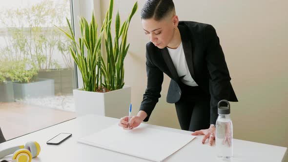 Businesswoman making sketches on paper in office