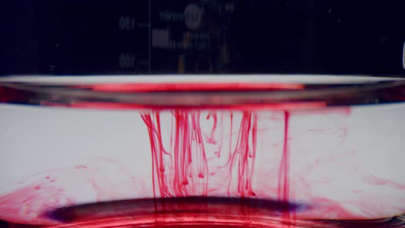 Lab Glassware with Blood Sample. Red Chemical Reagent Flowing in Water