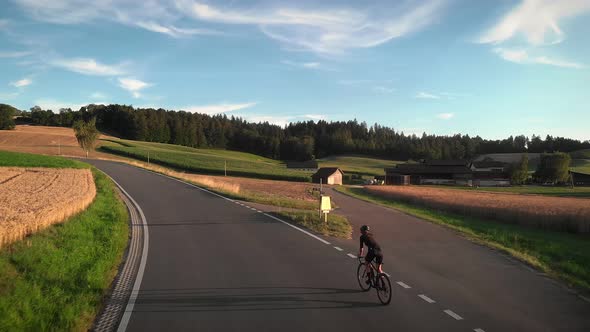 Road cyclist cycling on bike in evening sunset lights 