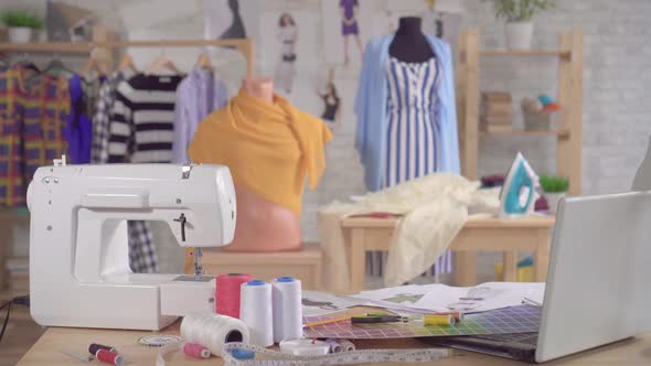 Sewing Machine and Sewing Supplies on the Table in the Studio of a Fashion Designer