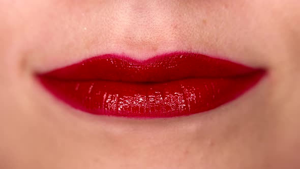 Woman Applying Liquid Red Gloss or Lipstick on Natural Sexy Lips