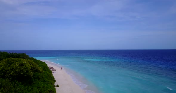 Luxury overhead tourism shot of a white paradise beach and aqua blue water background in hi res 4K