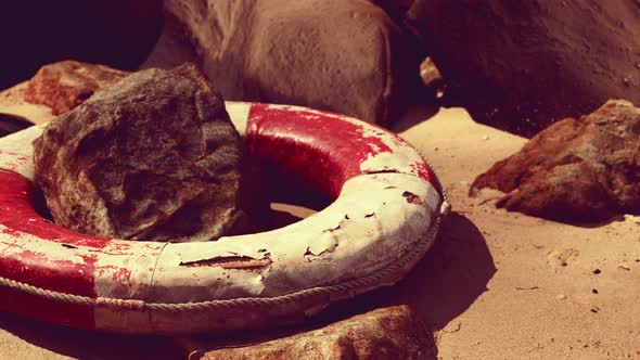 Old Life Buoy on Sand in Sunset