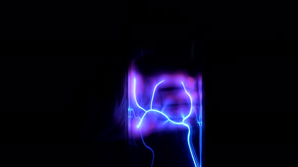 Child Leads His Hand Over an Electric Tesla Tube on a Black Background