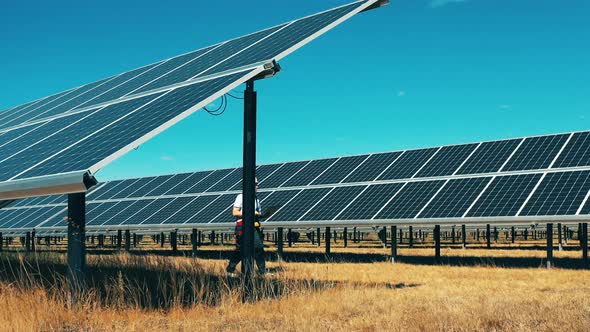 Solar Electric Plant with a Male Worker Walking Along It