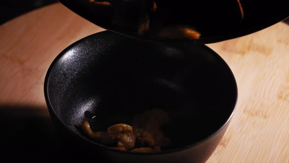 Transferring Fried Chicken Breast Meat From Pan Into Bowl. close up