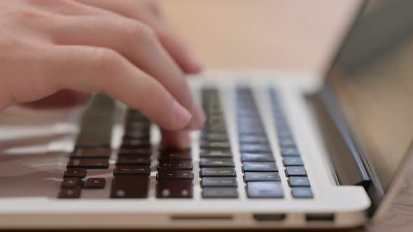 Male Hands Typing on Laptop Keyboard Close Up