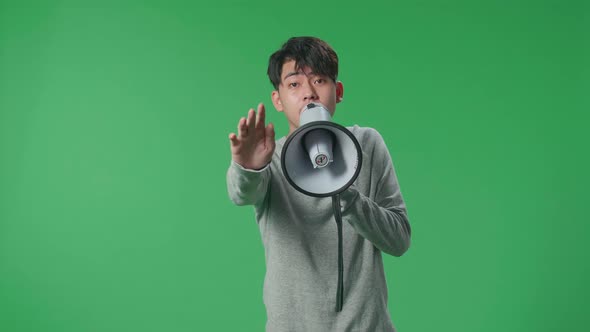 Asian Man Speaking On Megaphone In The Green Screen Studio