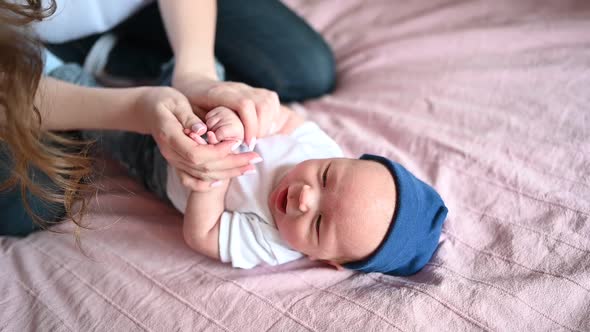 A Woman Holding a Baby on a Bed