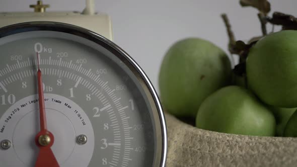 Kitchen weighing scales with apples medium panning shot