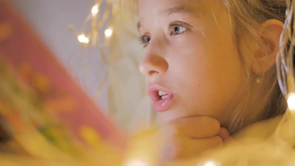 Family Bedtime Pretty Girl Reading Book in a Tent House at Night