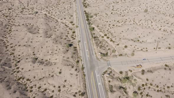 An orbiting aerial view over a desert road