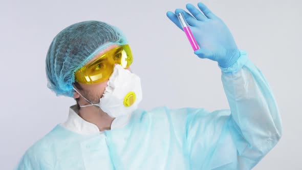 Young Medical Chemist Analyzing Test Tube with Pink Liquid in Protection Suit