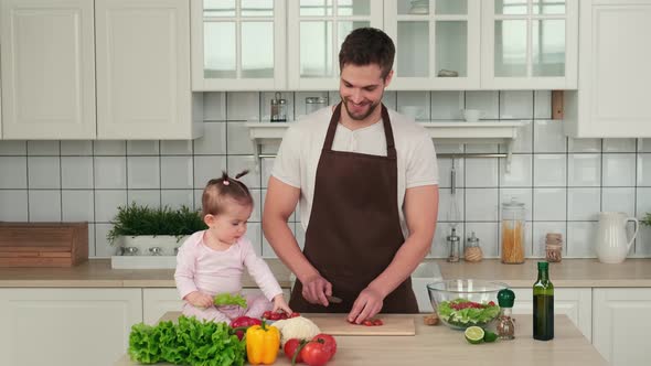 Dad and Little Daughter are Preparing a Vegan Salad