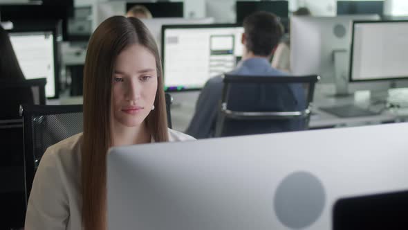 Attractive Young Woman Working on Decktop Computer While Working in Big Open Space Office