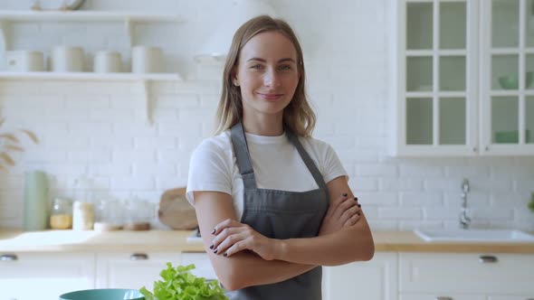 Portrait of Smiling Woman Standing on Kitchen. Lady in Apron Smiling at Camera.