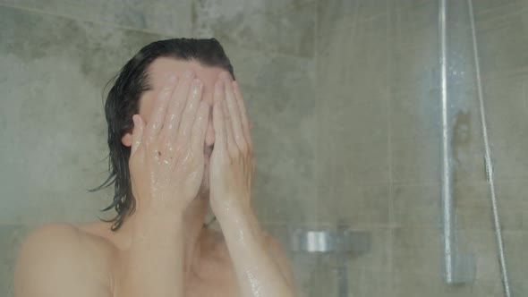 Handsome Young Long-haired Man Washing Face and Hair Taking Shower at Home