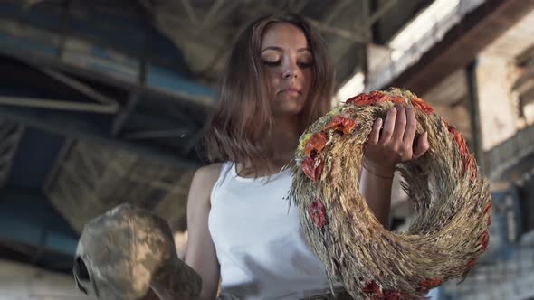 The Young Girl Chooses Between a Military Cap and a Wreath of Wheat in Abandoned Building