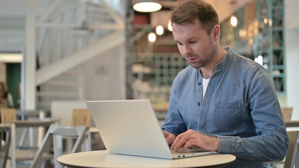 Professional Casual Man Using Laptop in Cafe 