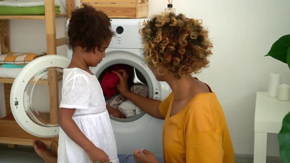 Afro Mom and Daughter Load Washer with Dirty Clothes Spbd