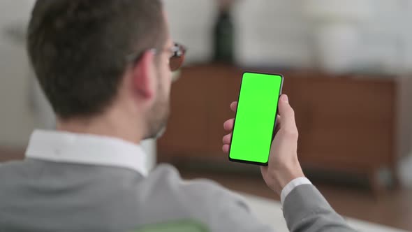 Rear View of Man Using Smartphone with Chroma Key Screen