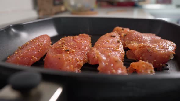 Cooking Turkey Steaks with Spices on a Grill Pan