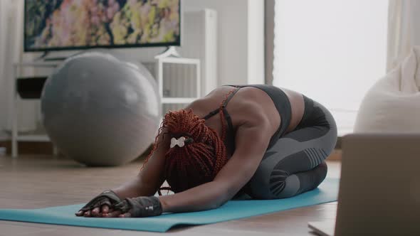 Fit Athletic Woman with Black Skin Sitting on Yoga Map During Aerobics Morning Workout
