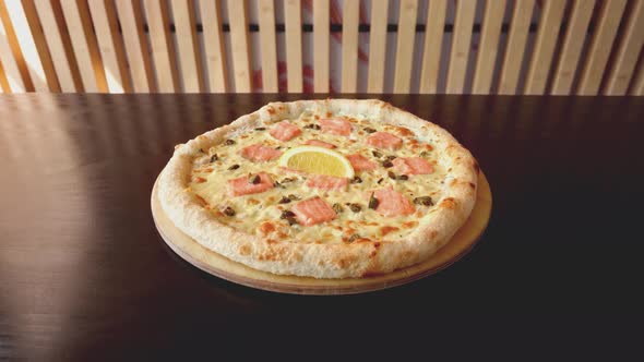 Fresh Baked Pizza with Salmon on Brown Counter in Restaurant