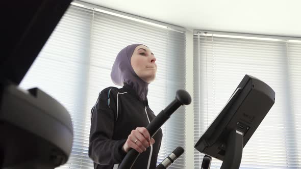 Portrait of a Sporty Woman in Hijab on a Step Simulator Fitness Muslim