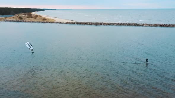 Aerial Drone View of a Corekites Kitesurfers Hydrofoiling  in Engure Port at in Baltic Sea