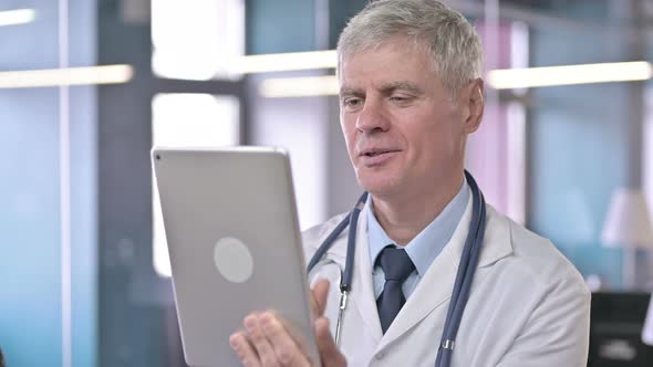 Portrait of Middle Aged Doctor Doing Video Chat on Tablet