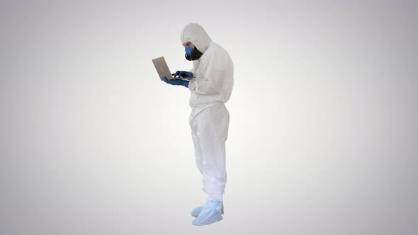 Medical Doctor in White Protective Uniform Using Laptop on Gradient Background.