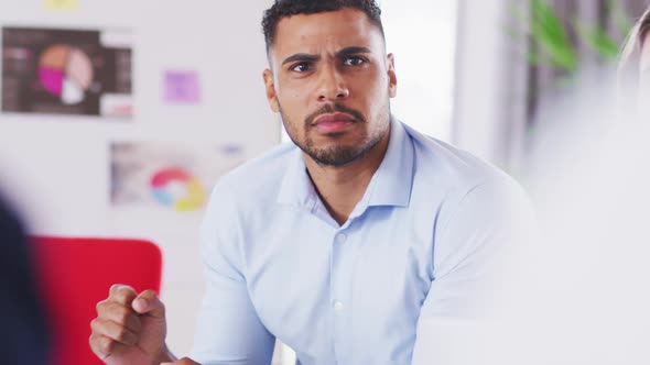 Professional businessman talking to his colleagues while sitting in modern office in slow motion