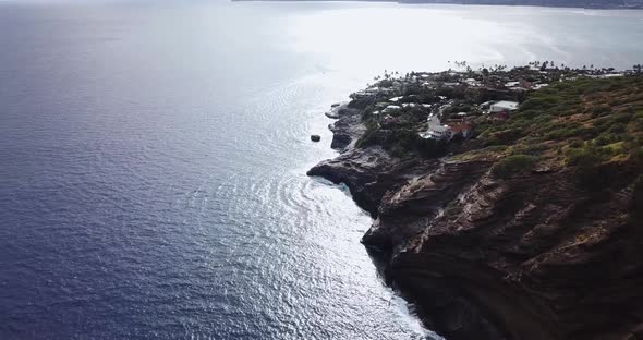 Drone shot of a cliffside beach that has both amazing houses and a nice views of the waves crashing