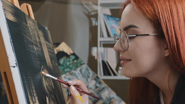 Side View Close Up Redhaired 20s Woman Talented Artist Girl in Glasses Female Painter Paints Picture