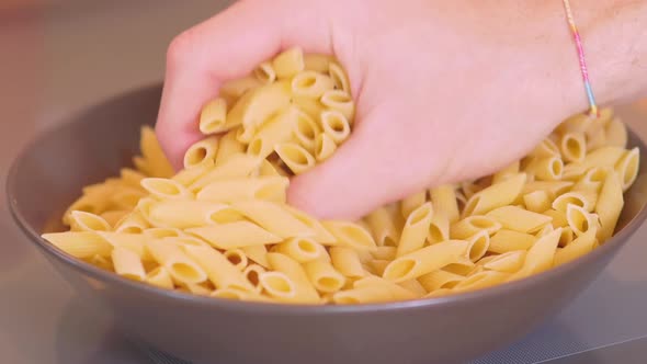 Taking raw pasta by hand in slow-motion