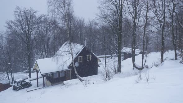 Wooden House During Hard Snowfall