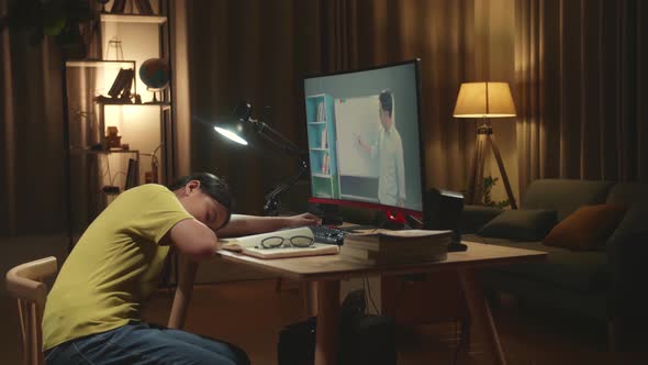 Girl Sleeping On The Table While Distance Learning With Online Teacher On Computer Screen From Home