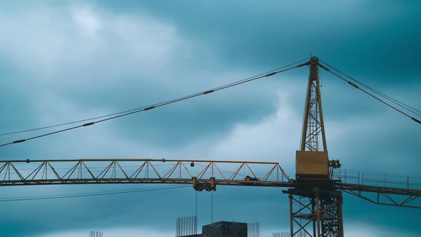 Timelapse footage big industrial construction crane with beautiful cloudy sky background.