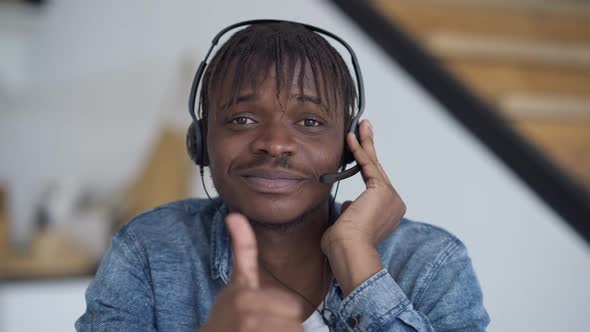 Closeup of Smiling African American Man in Headphones Showing Thumb Up Looking at Camera